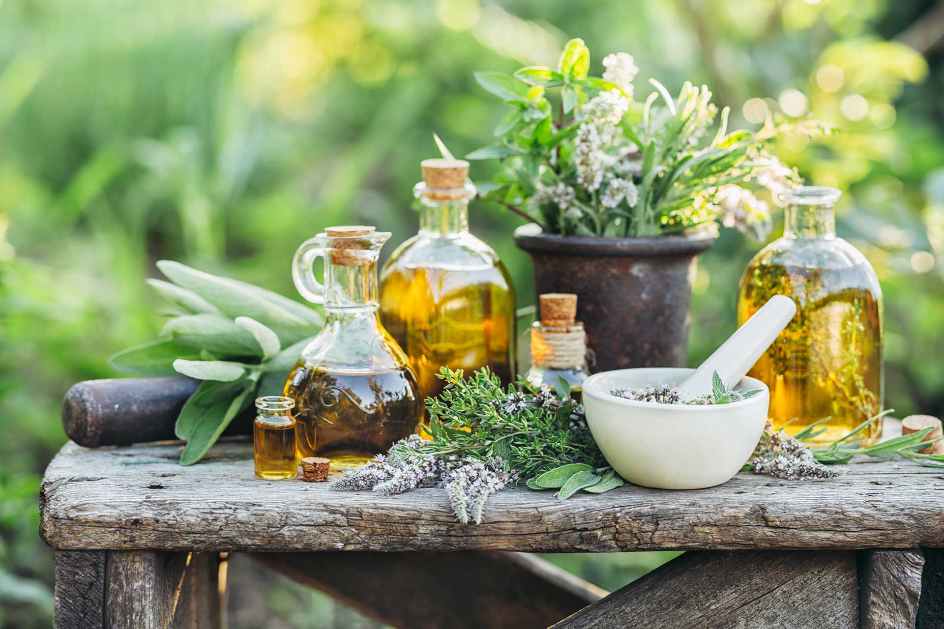 Selection of oils and herbs on wooden table