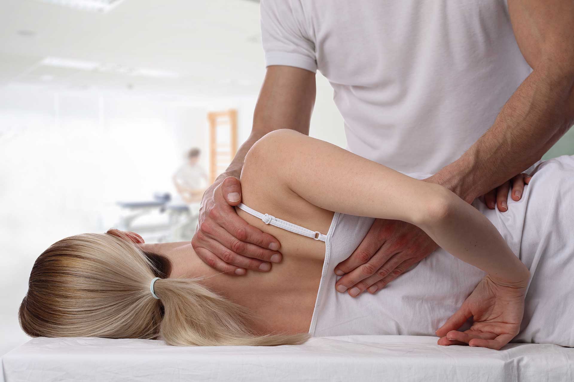 Patient on table with therapist performing Osteopathy treatment